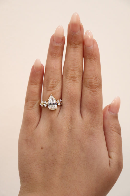 Hand wearing a diamond ring on a plain background