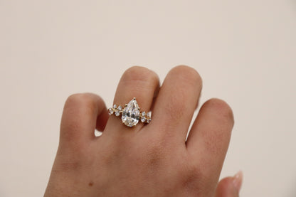 Hand wearing a diamond ring on a plain background