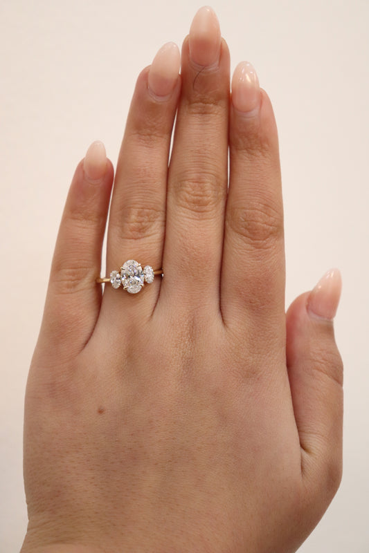 Hand wearing an Oval Trilogy Engagement Ring with Ovals on the side