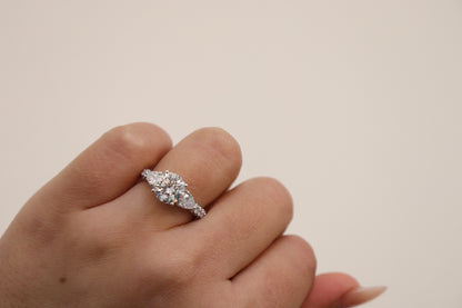 Diamond ring on a finger against a plain background