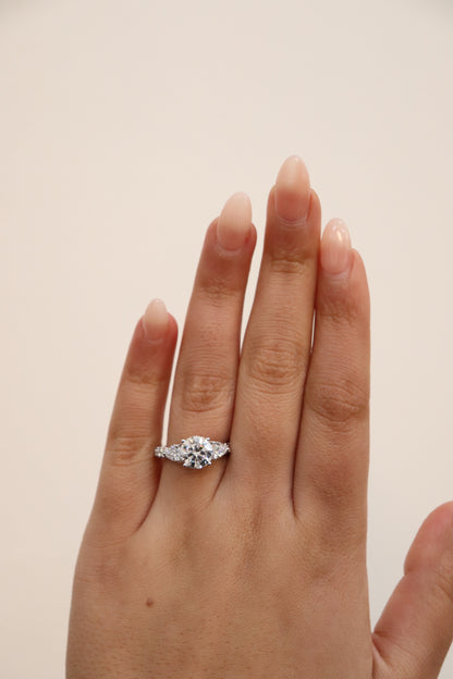 Diamond ring on a hand against a beige background