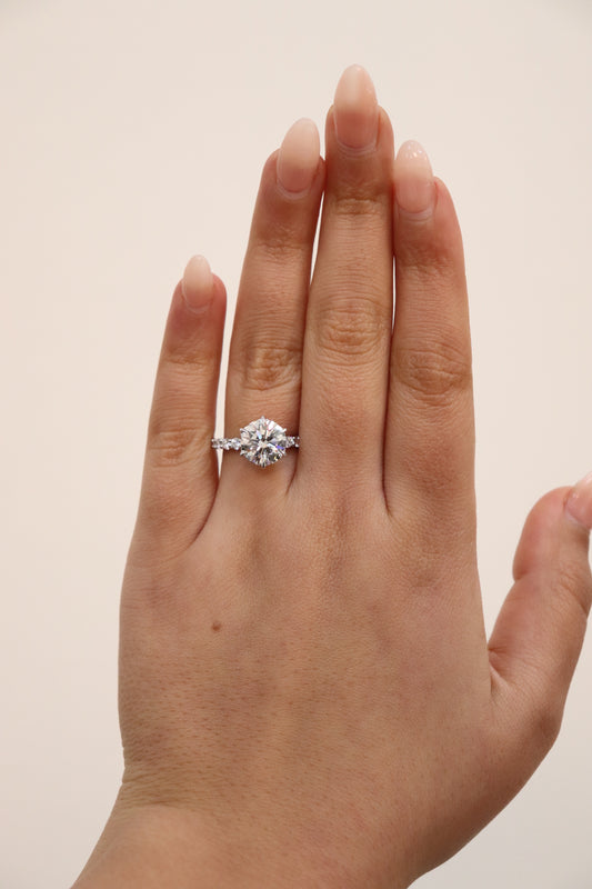 Round Brilliant cut ring with a pavè band on a hand