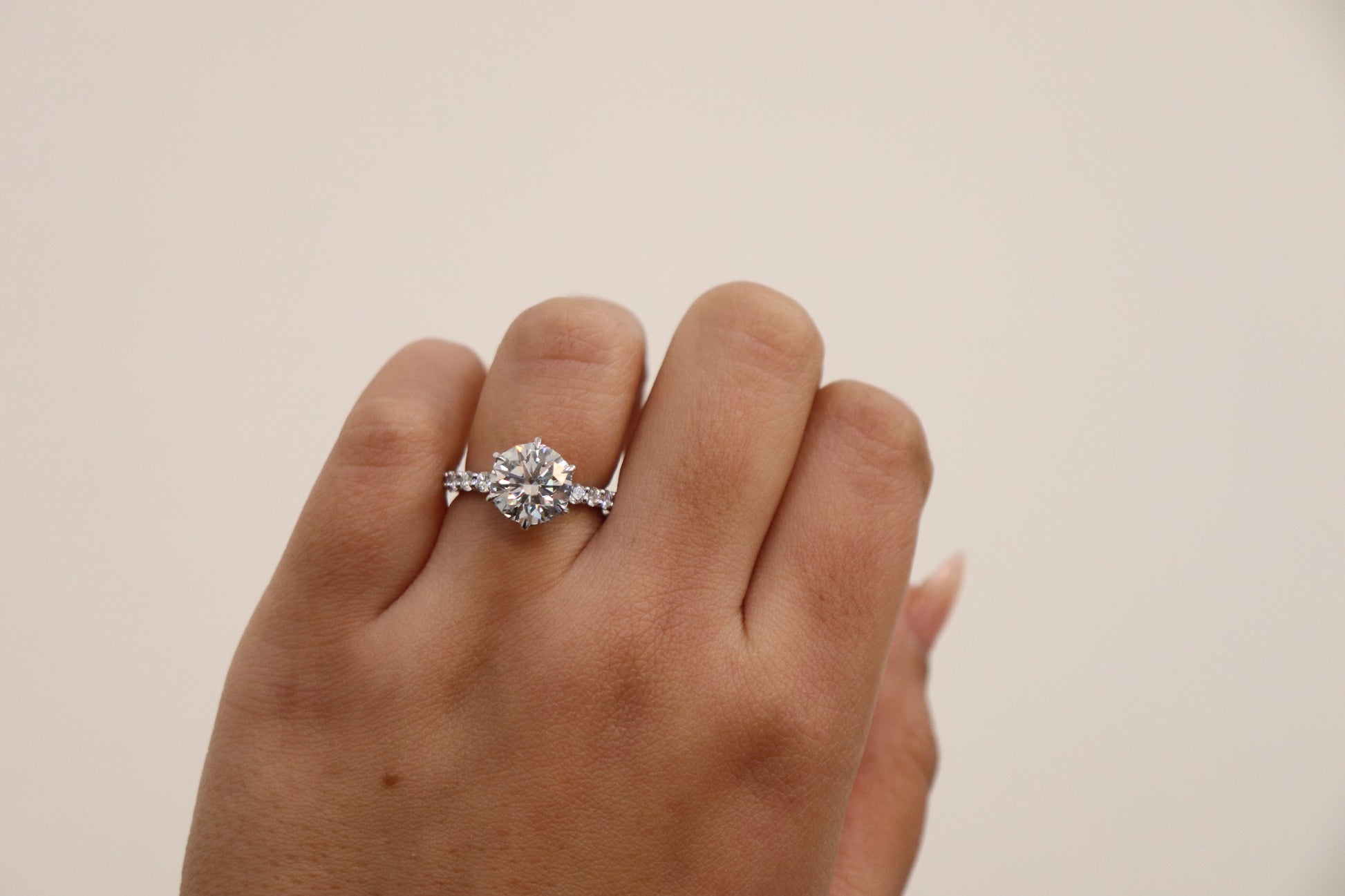 Round Brilliant cut ring with a pavè band on a hand